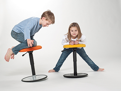 Zwei Kinder testen die Bewegungsfreiheit mit dem LeitnerWipp Hocker ©Leitner Ergomöbel