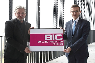 Wirtschafts-Landesrat Markus Achleitner präsentiert gemeinsam mit Cluster-Manager Erich Gaffal das neue Logo des Building Innovation Clusters ©Land OÖ/Kauder
